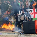 Protestors throw a blazing garbage