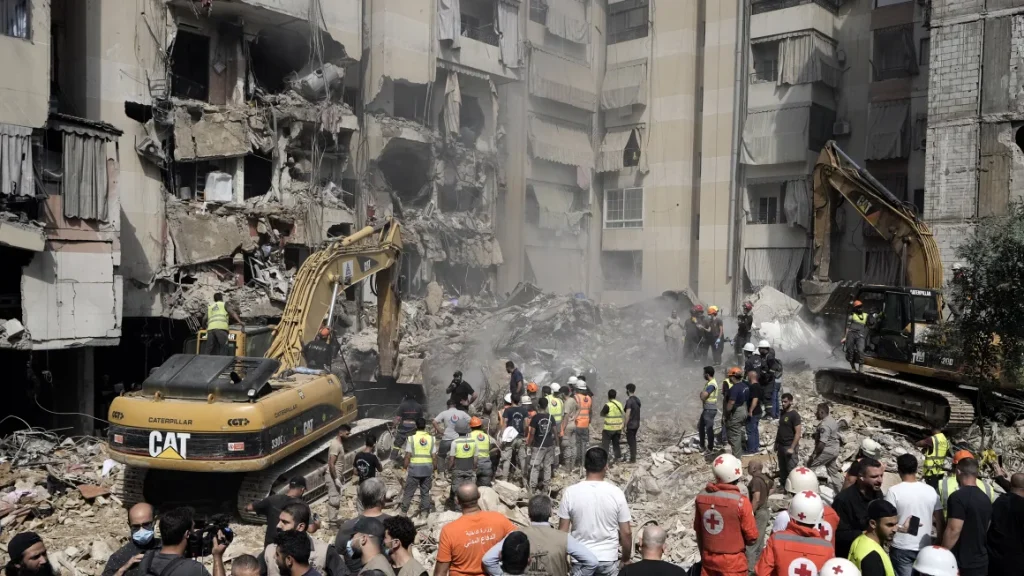 Emergency workers use excavators to clear the rubble